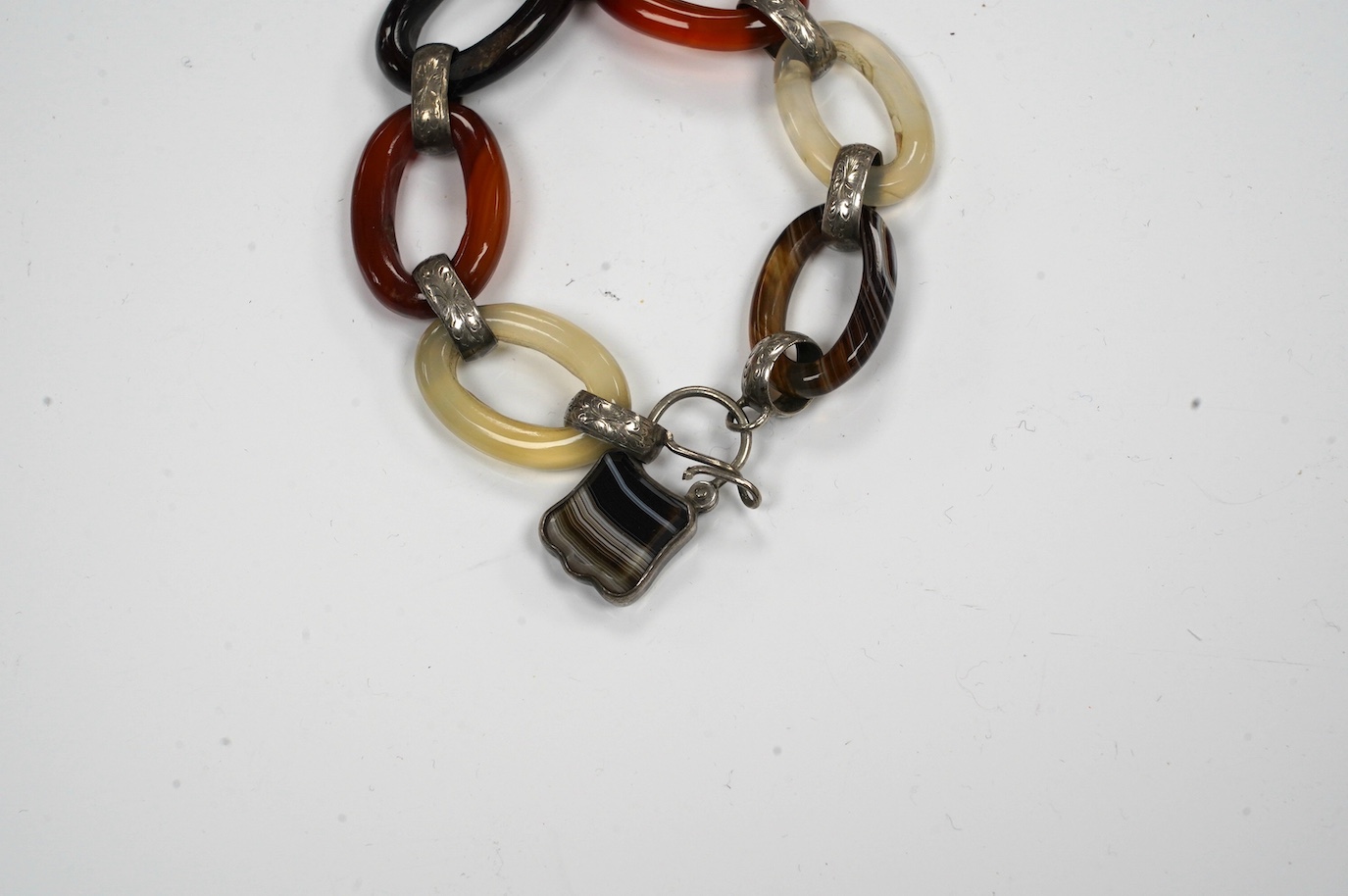 A white metal, carnelian and banded agate set loop link bracelet, 14cm. Condition - poor